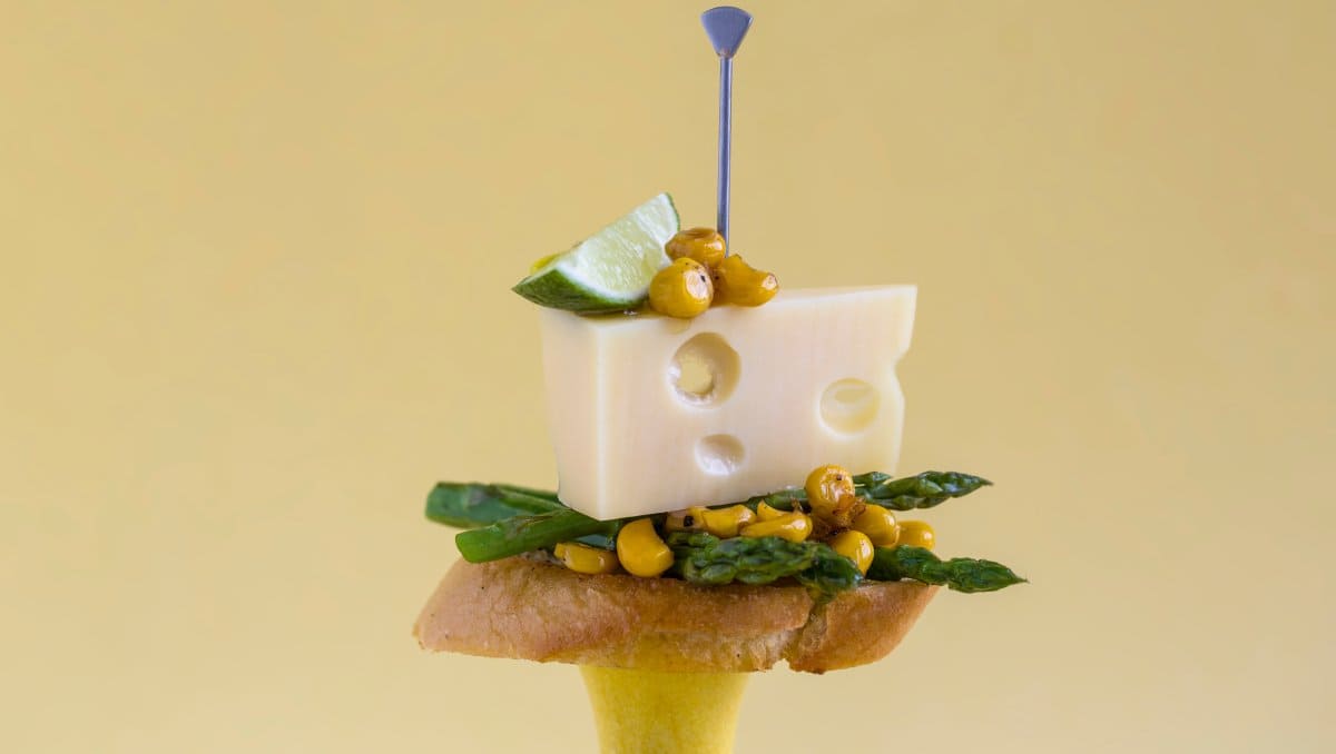 Pintxos på pinne. Jarlsberg®  med finhøvlet asparges, grillet mais, lime og olivenolje.
