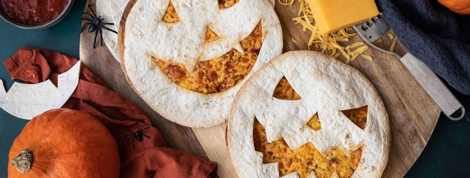 Bildet viser to qesadillaer med ukuttet halloween ansikt på