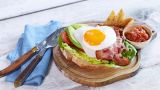 Sandwich med stekt egg, bacon, salat og kalkunpålegg