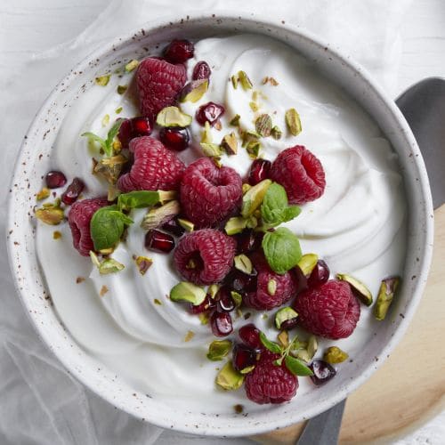 Proteinfrokost med gresk type yoghurt, friske bringebær, granateple og pistasjnøtter