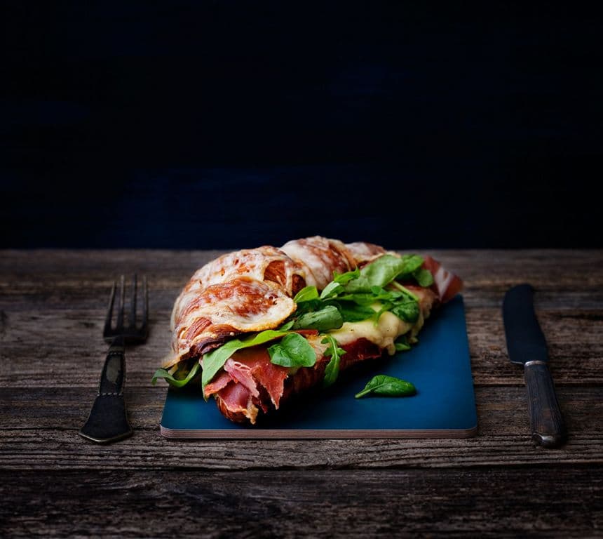 Tallerken med kremet pasta og tomater med en porsjon torsk på toppen