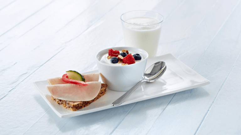 Frokost med brødskive yoghurt med bær og syrnet melk