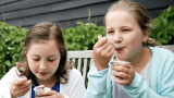 Jenter spiser yoghurt