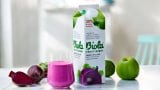 Biola® Frukt + Grønt på bord med eple, rødbet i glass og på kartong.