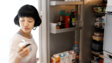Kvinne henter matfløte fra kjøleskap