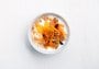 Naturell yoghurt i skål med gulrot, hasselnøtter, appelsin, musli og kanel