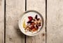 Yoghurt i skål med plommer, musli og kardemomme