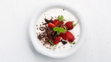Naturell yoghurt i skål med jordbær, sjokolade, pepper og sitronmelisse