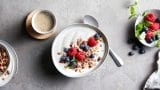 Yoghurt i skål toppet med bær og granola.