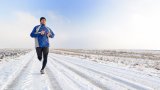 Mann jogger ute i snøen