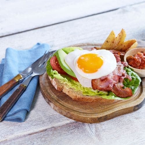 Sandwich med stekt egg, bacon, salat og kalkunpålegg
