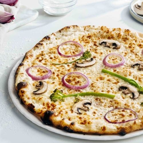 Hvit pizza med sopp, brokkolini og rødløk
