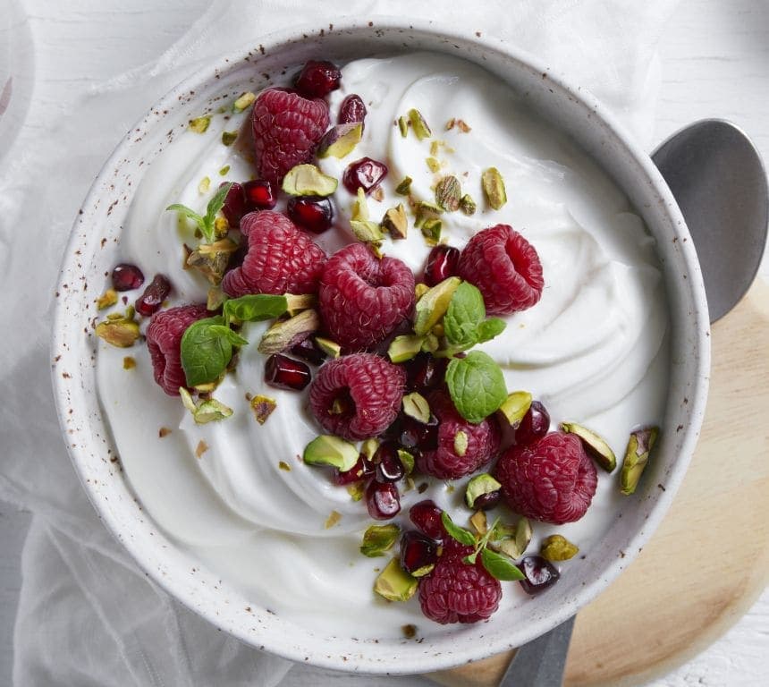 Proteinfrokost med gresk type yoghurt, friske bringebær, granateple og pistasjnøtter